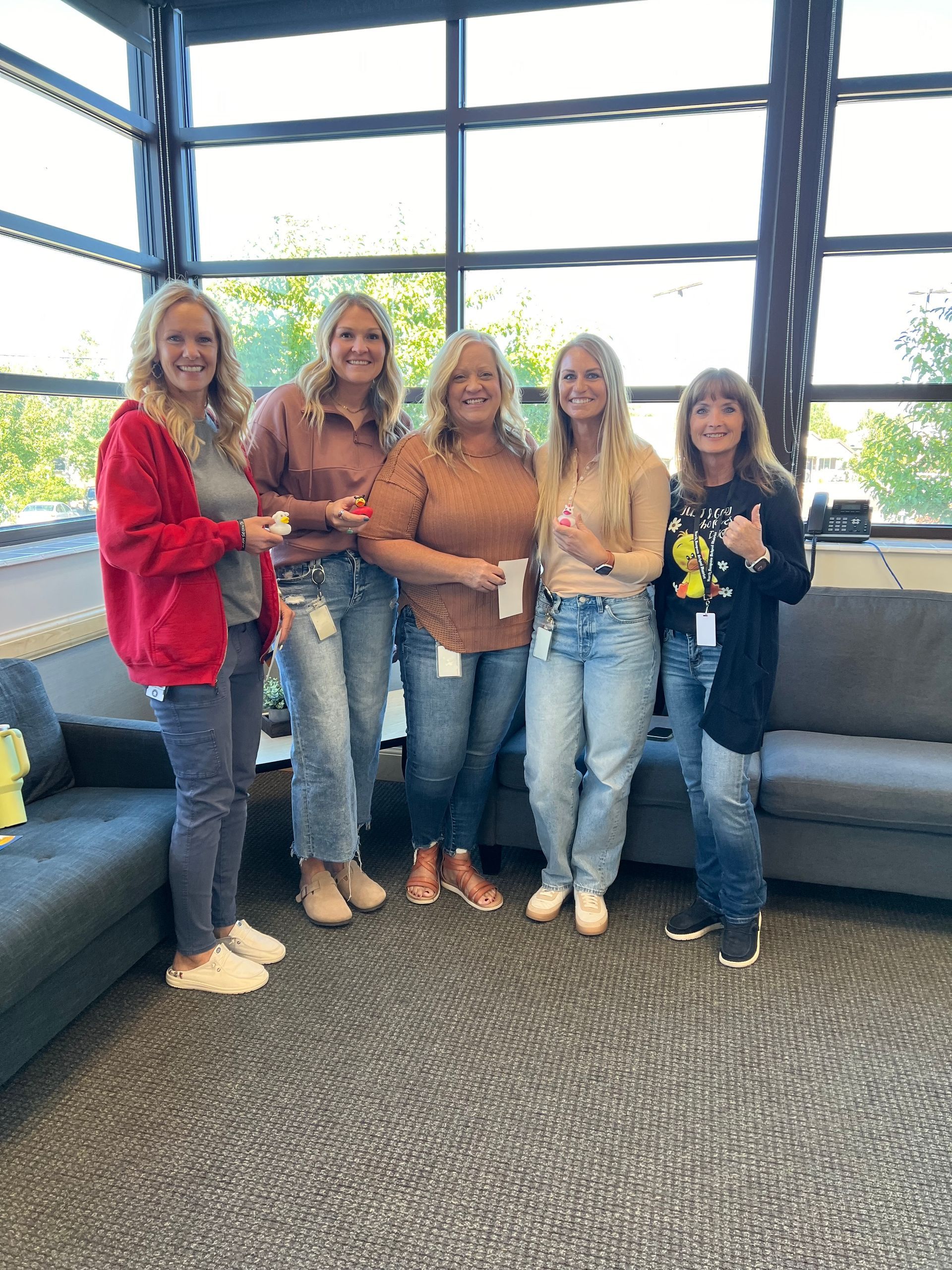 A group of women are posing for a picture in a living room.