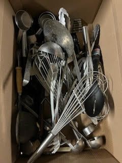 A box filled with a variety of kitchen utensils.