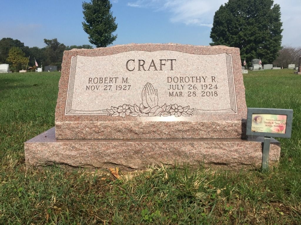 Tombstone of Robert and Dorothy Craft, dates of birth and death visible, in a grassy cemetery.