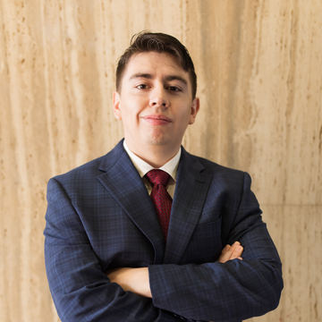 A man in a suit and tie with his arms crossed