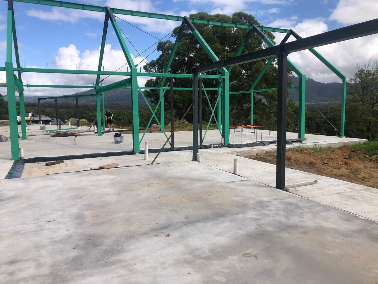 A Green Metal Structure is Being Built on a Concrete Floor — TC Pest & Termite Control In Mittagong, NSW