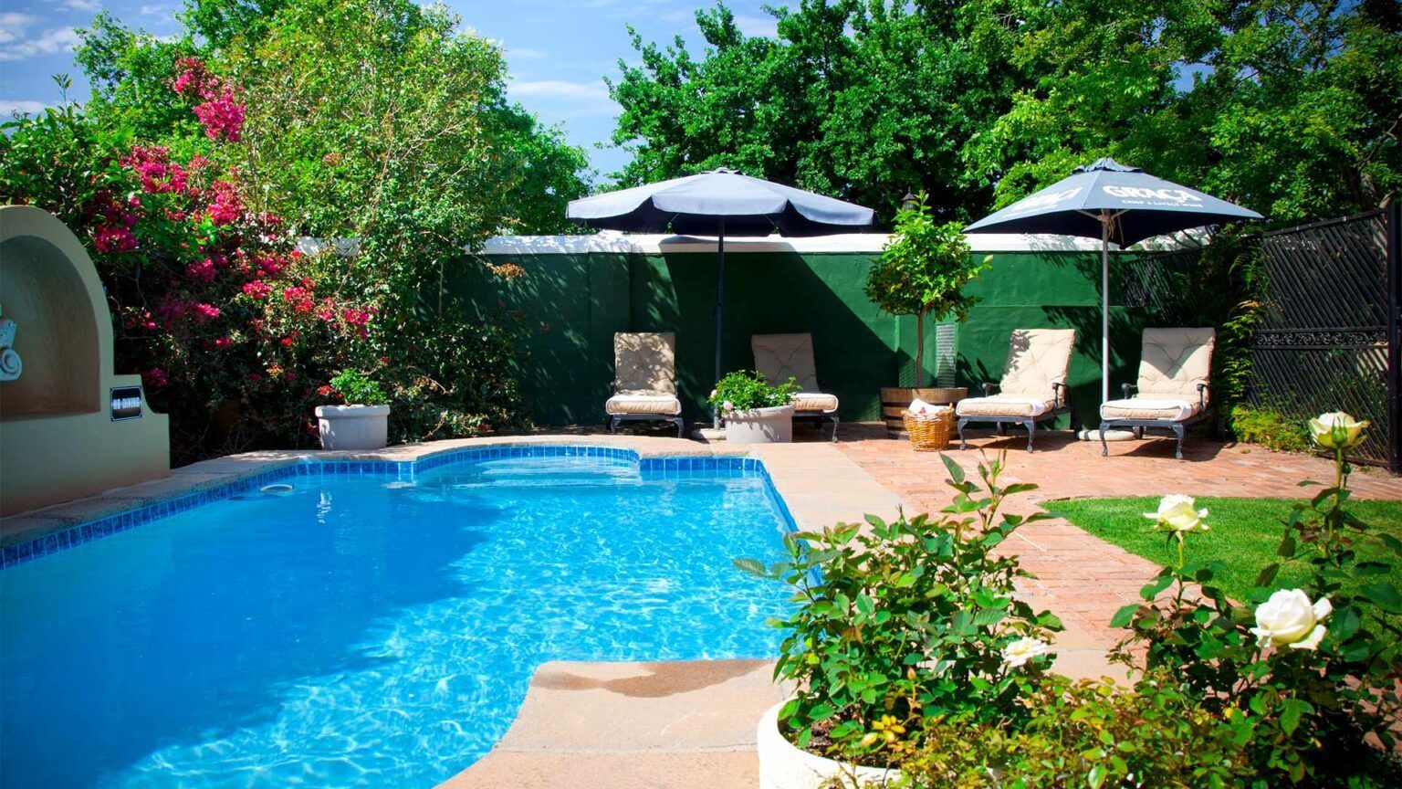 A large swimming pool surrounded by chairs and umbrellas