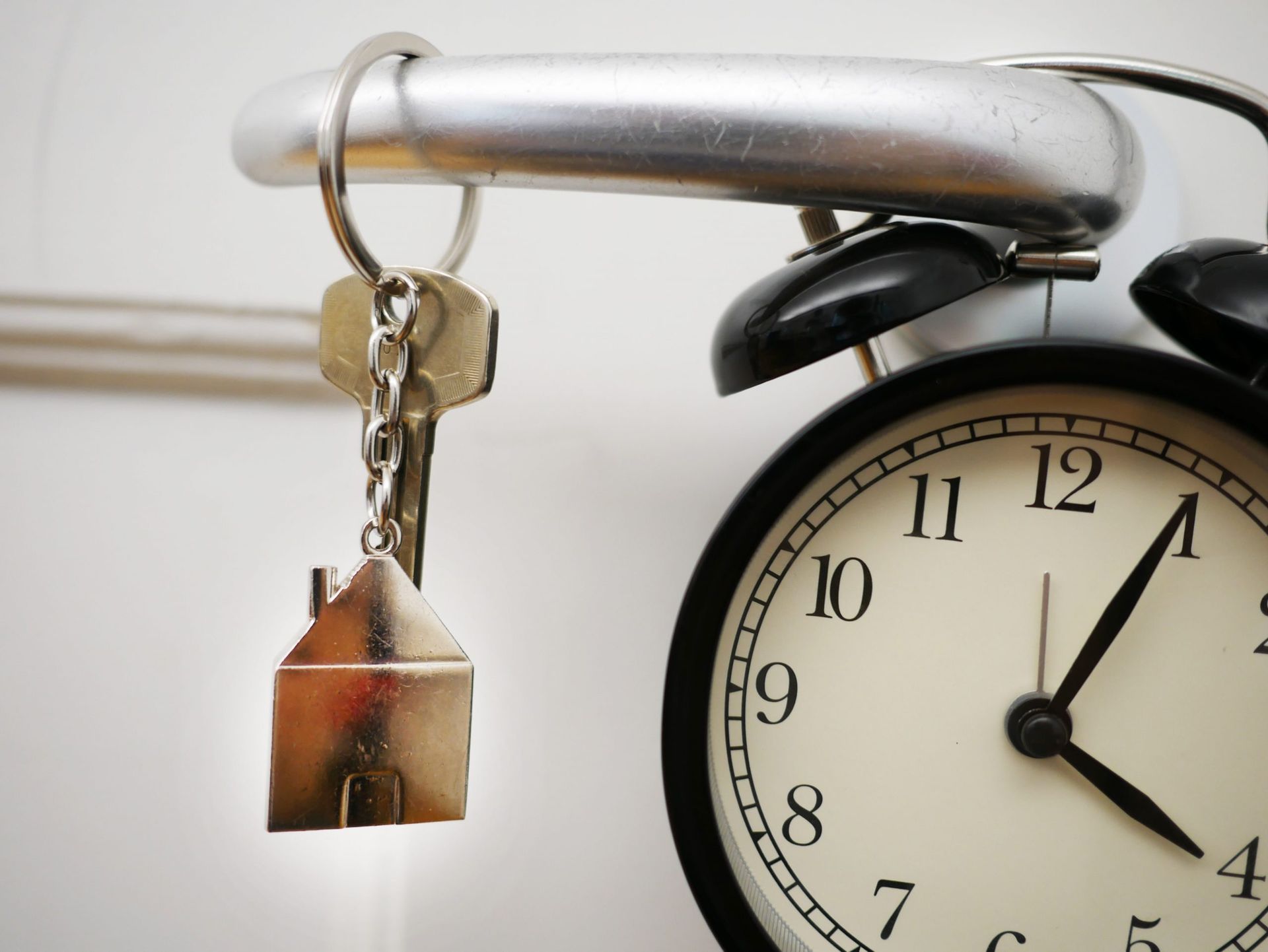 An alarm clock with a house keychain next to it