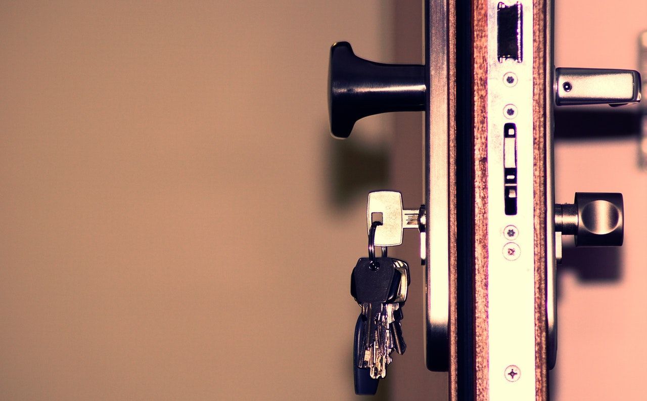 A close up of a door lock with keys in it.