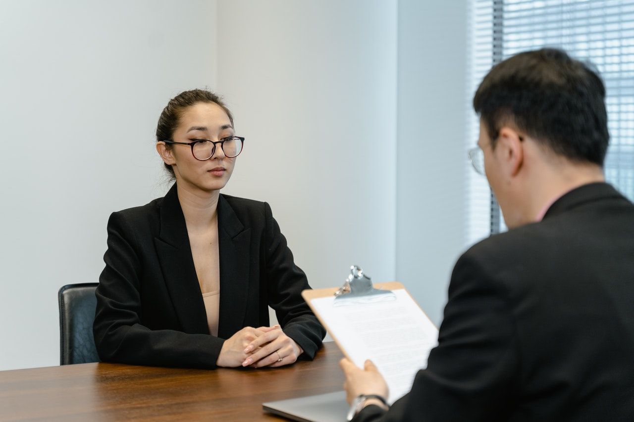 A man and a woman are sitting at a table having a job interview.