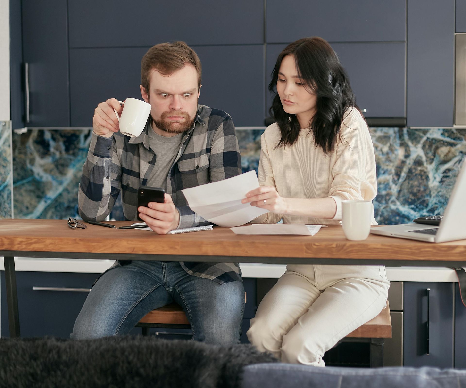 A man and a woman are sitting at a table looking at papers.