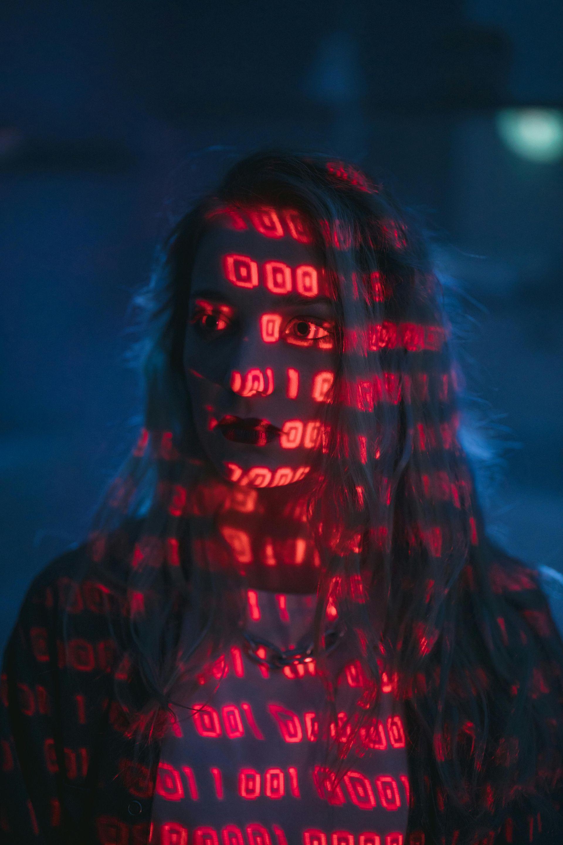 A woman 's face is covered in red numbers and letters.