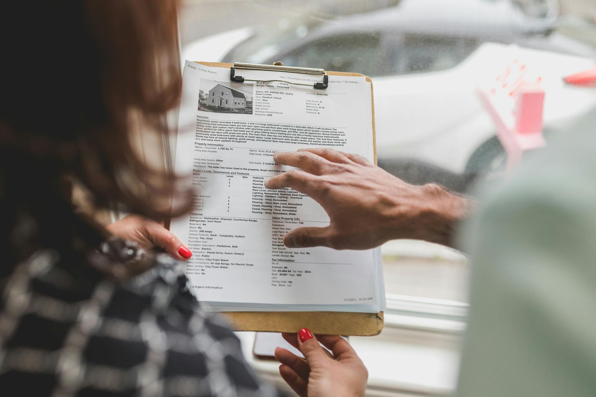 A man and a woman are looking at a clipboard with a menu on it.