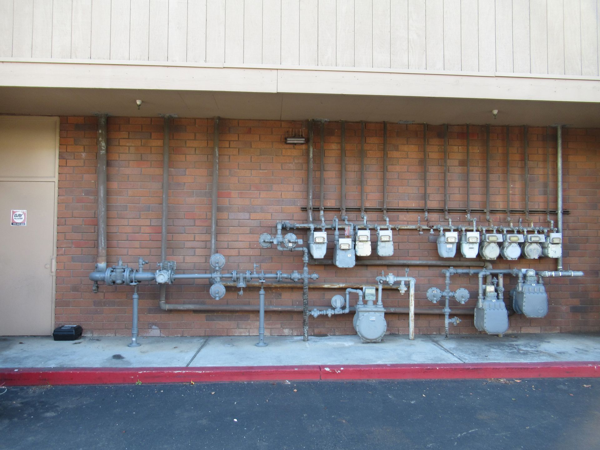 A brick wall with a lot of pipes and meters on it