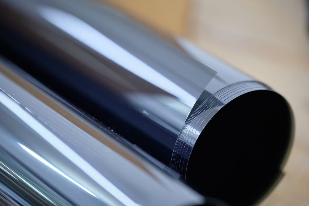 Rolls of dark, shiny film, possibly window tint, on a light-colored surface. — Coolum Smash Repairs in Coolum Beach, QLD