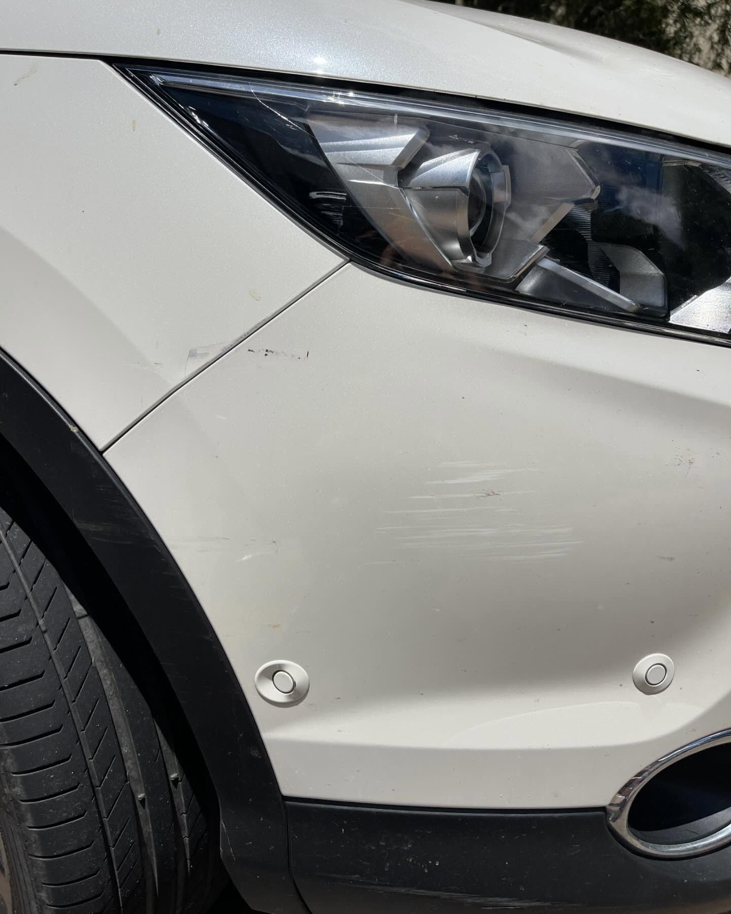 White car bumper with scratches and two parking sensors. — Coolum Smash Repairs in Coolum Beach, QLD