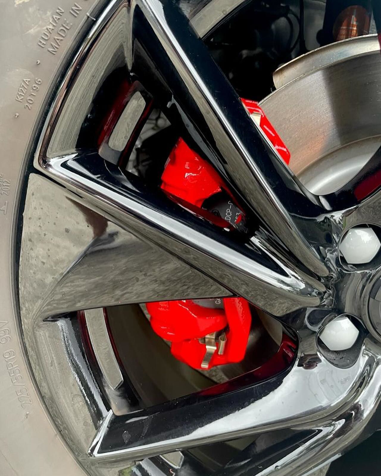 Close-up of a shiny black car wheel with a red brake caliper. — Coolum Smash Repairs in Coolum Beach, QLD
