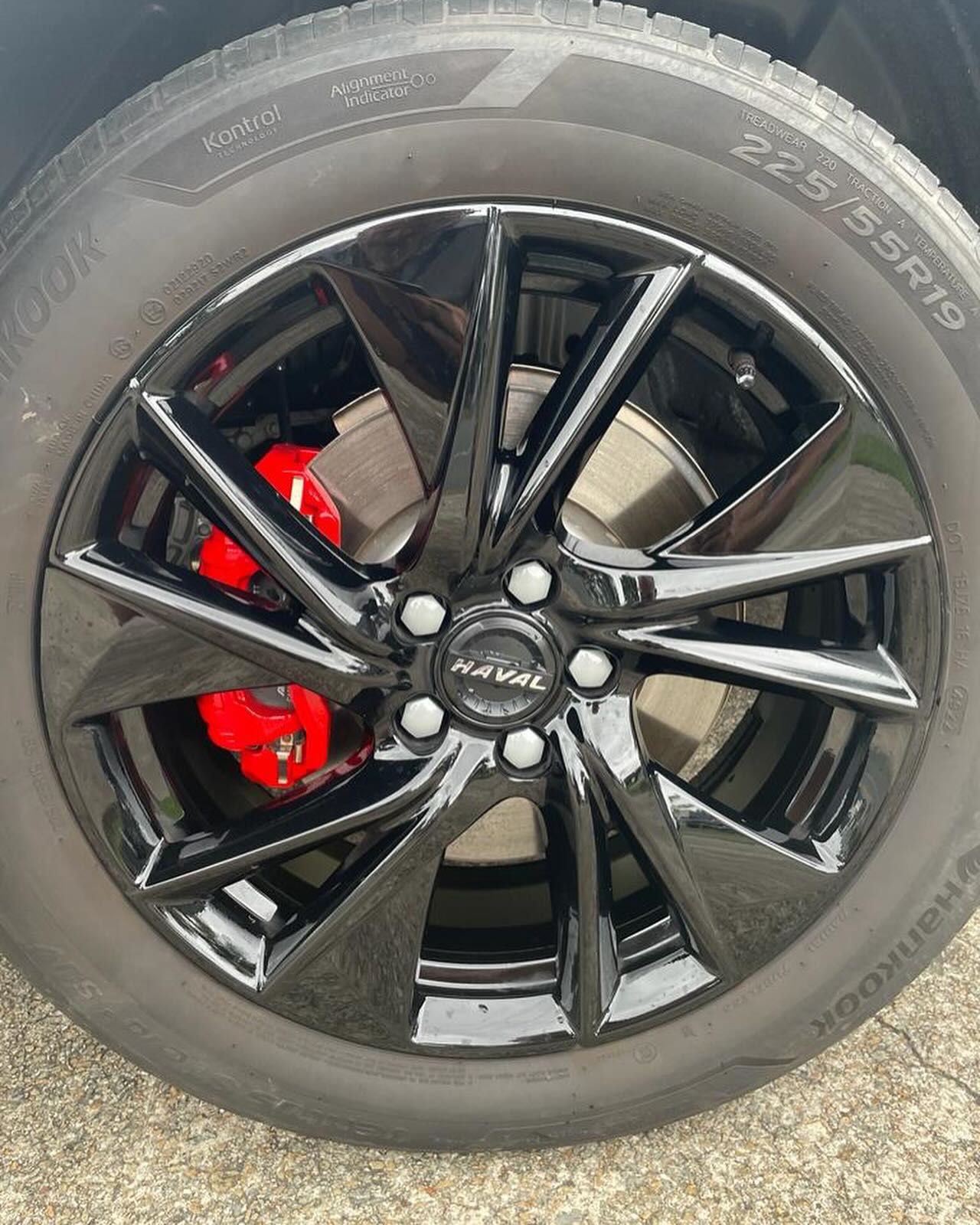 Black car wheel with glossy finish, red brake calipers, and Hankook tire. — Coolum Smash Repairs in Coolum Beach, QLD