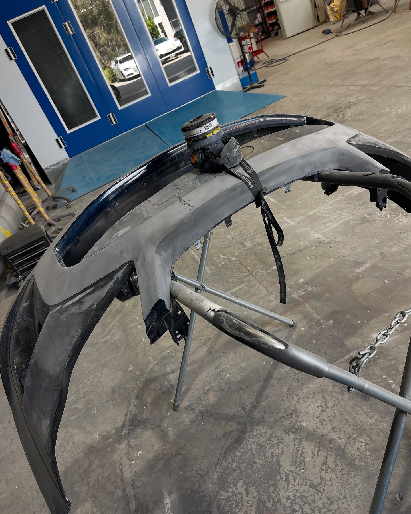 Car bumper on a stand in a workshop, ready for repair or painting. — Coolum Smash Repairs in Coolum Beach, QLD