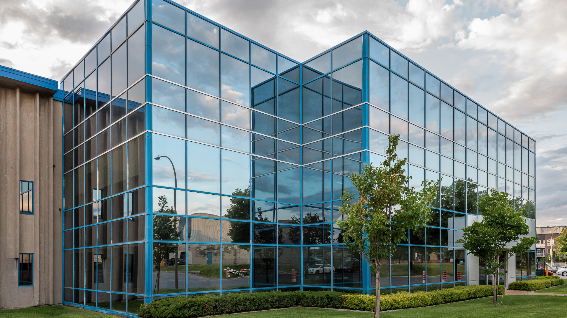 A large building with a lot of windows and trees in front of it.