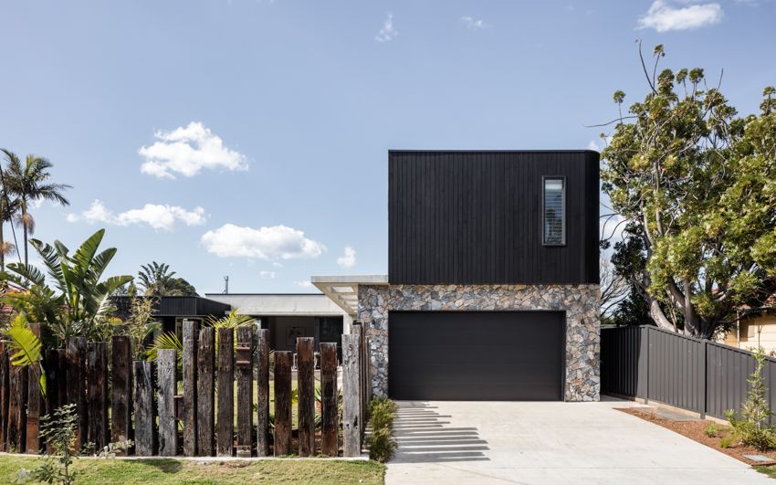 Modern house with black facade, stone wall, and wooden fence — Make The Mark Building Services in Illawarra, NSW