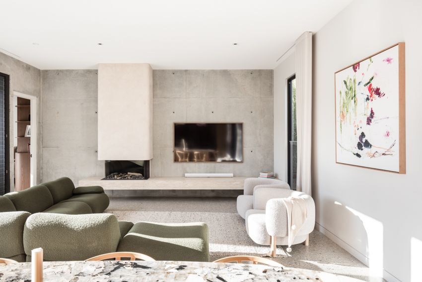 Modern living room with concrete wall, fireplace, large TV, olive green sofa, and abstract art — Make The Mark Building Services in Illawarra, NSW