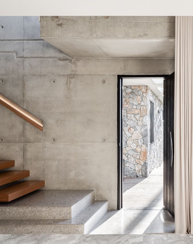 Concrete staircase with wood treads next to an open doorway to a stone-walled area — Make The Mark Building Services in Illawarra, NSW