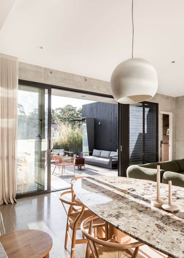 Interior view with open sliding doors to patio; light-filled space with a pendant light, and a kitchen island with bar stools — Make The Mark Building Services in Illawarra, NSW