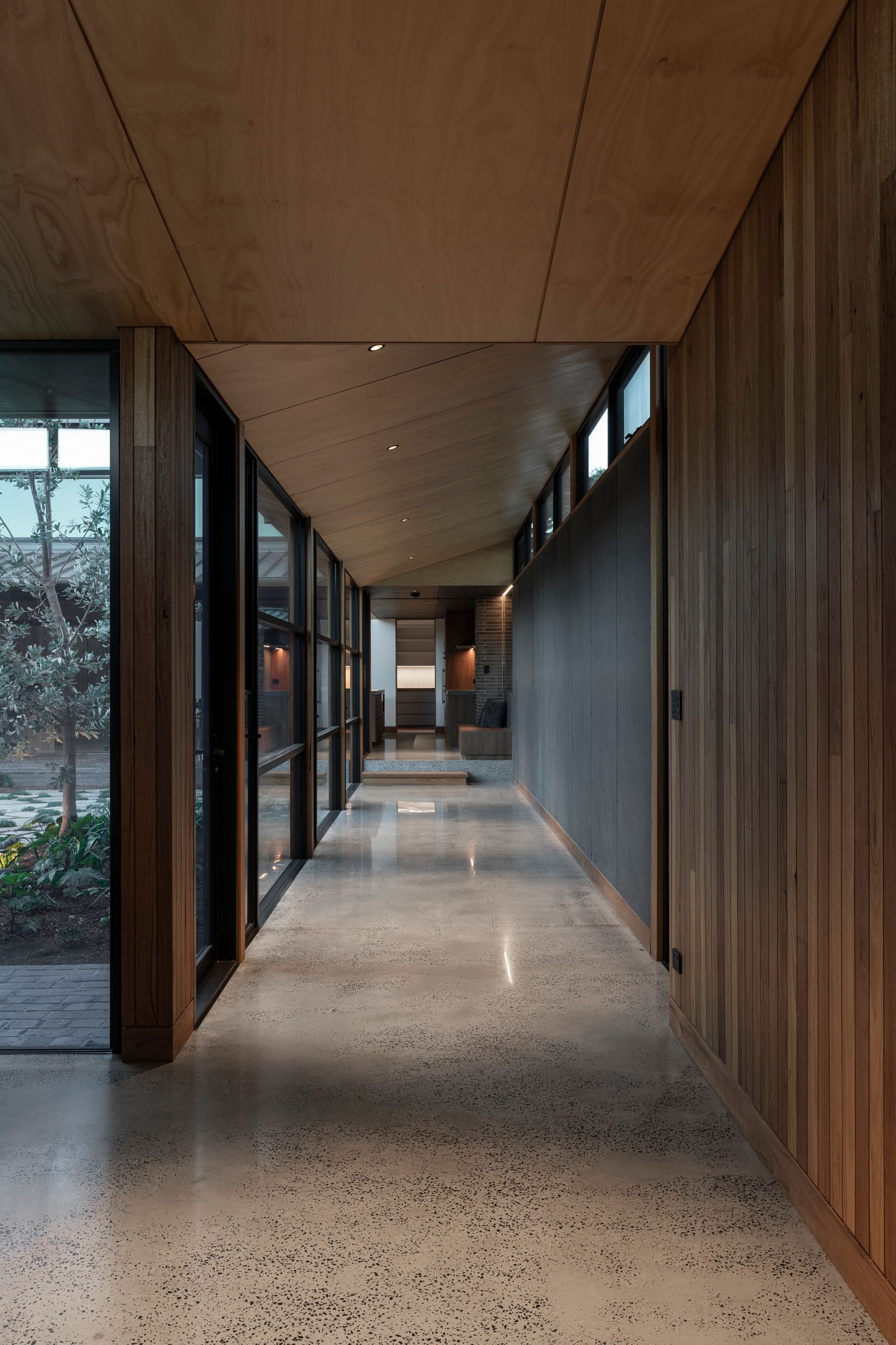 Long, narrow hallway with wood paneling and large windows. Polished concrete floor, and light fixtures — Make The Mark Building Services in Illawarra, NSW