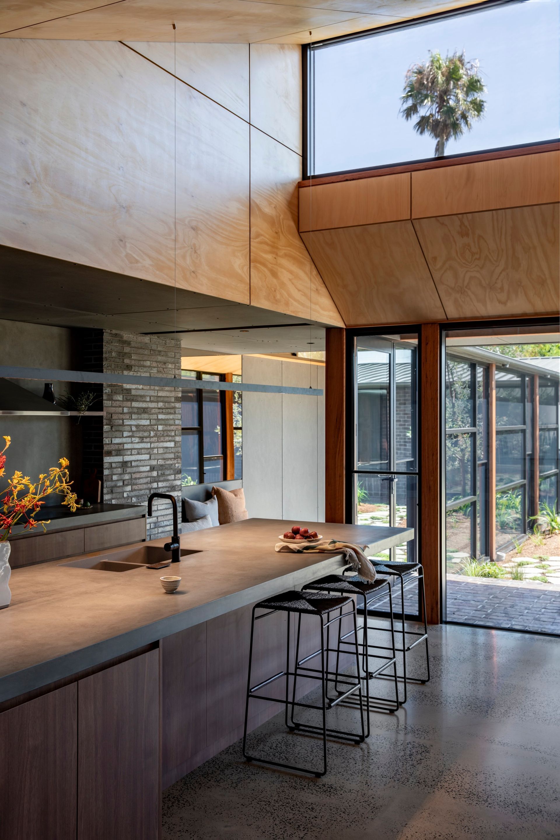 Modern kitchen with concrete countertop, wood cabinetry, and large windows — Make The Mark Building Services in Illawarra, NSW