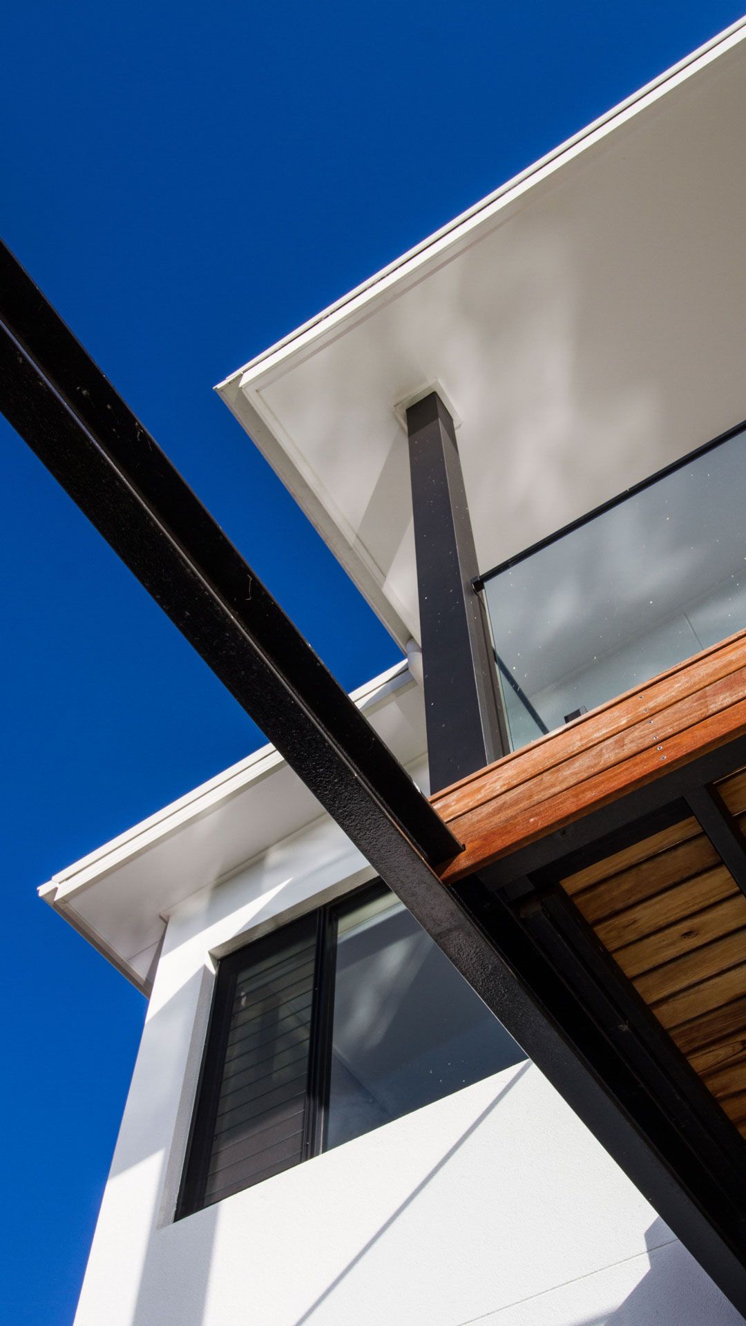Modern white building with black beams and blue sky  — Make The Mark Building Services in Illawarra, NSW