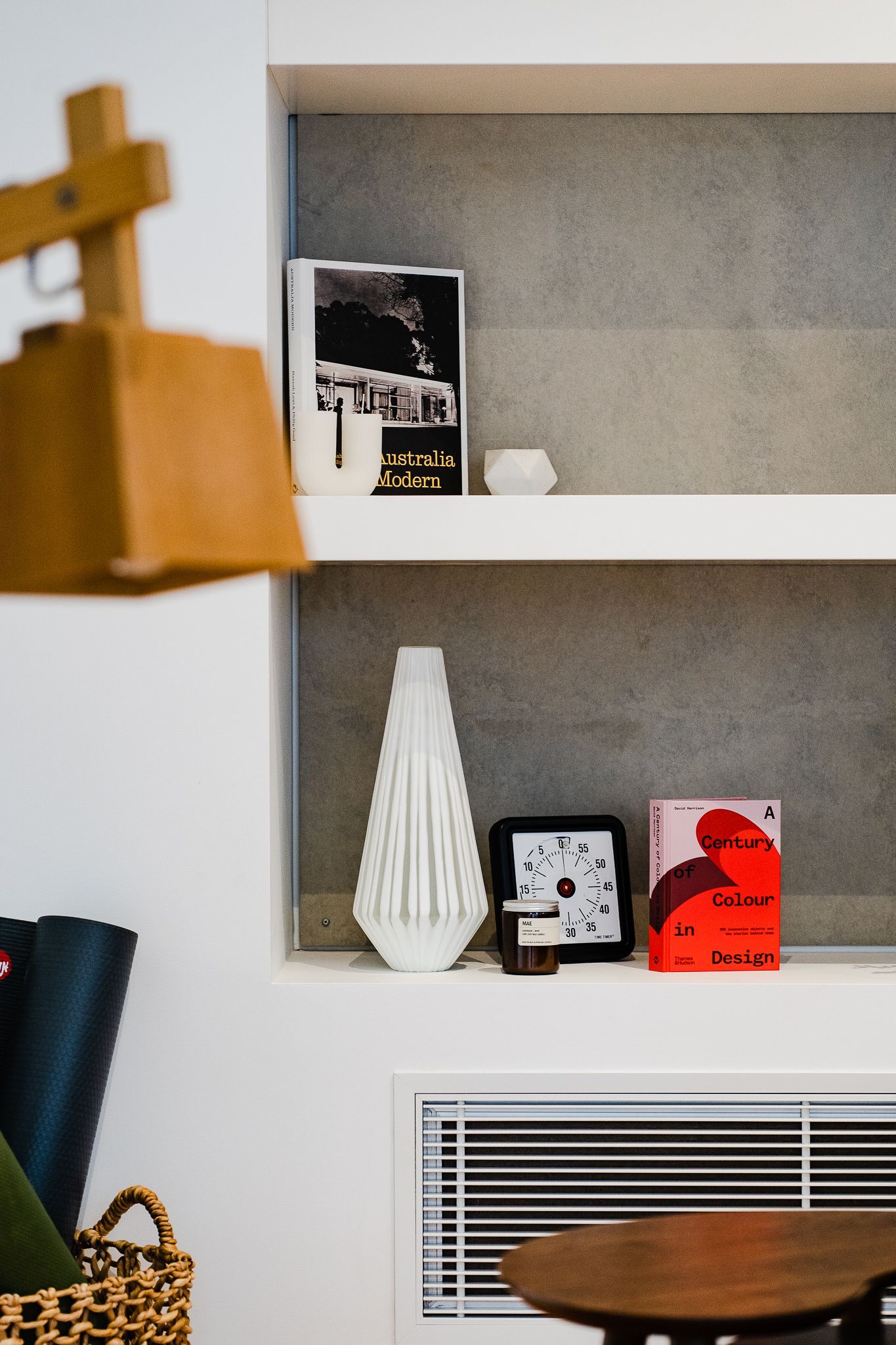 Shelves with decor: white vase, black clock, pink book. Yoga mats and basket in the corner - Make The Mark Building Services in Mangerton, NSW