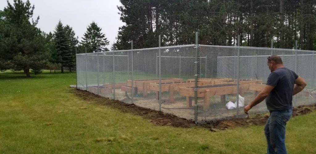 Exterior Fence — Man Standing Outside the Fence in Deerwood, MN