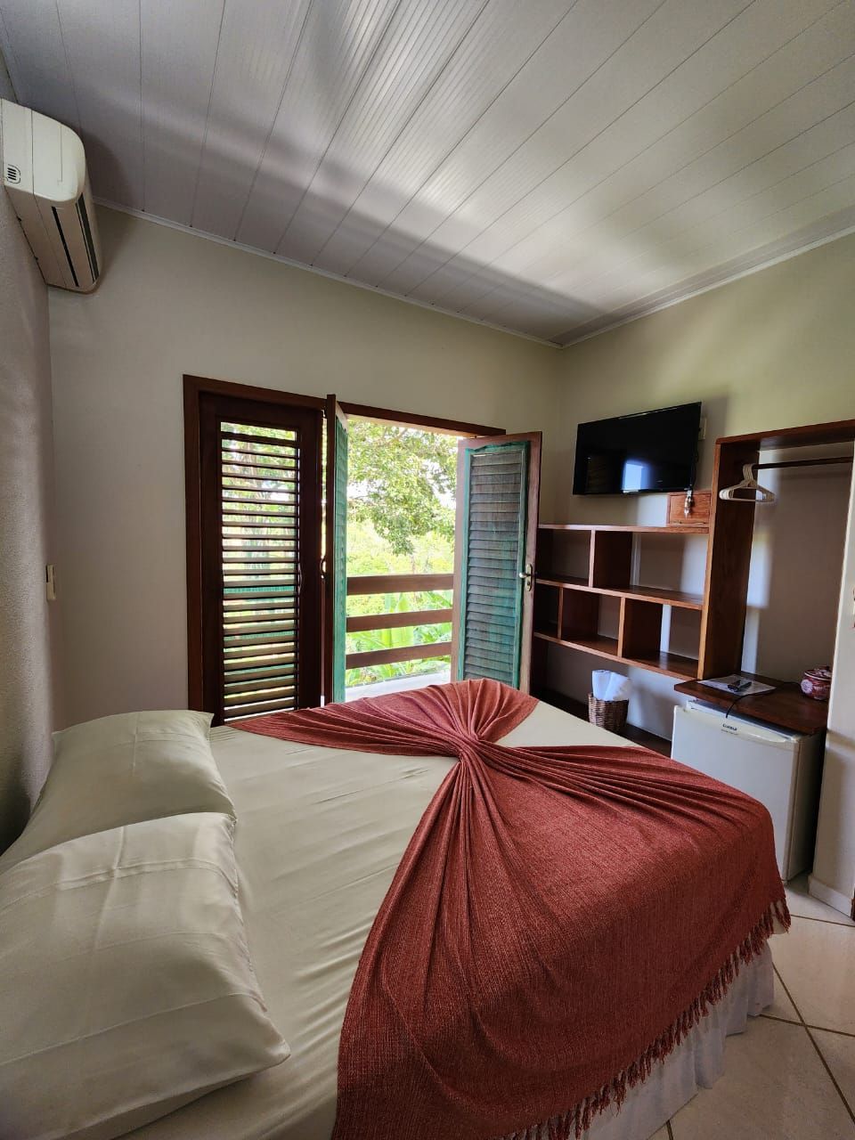 Um quarto com uma cama king size e uma varanda.-Pousada-A-Flor-Da-Terra