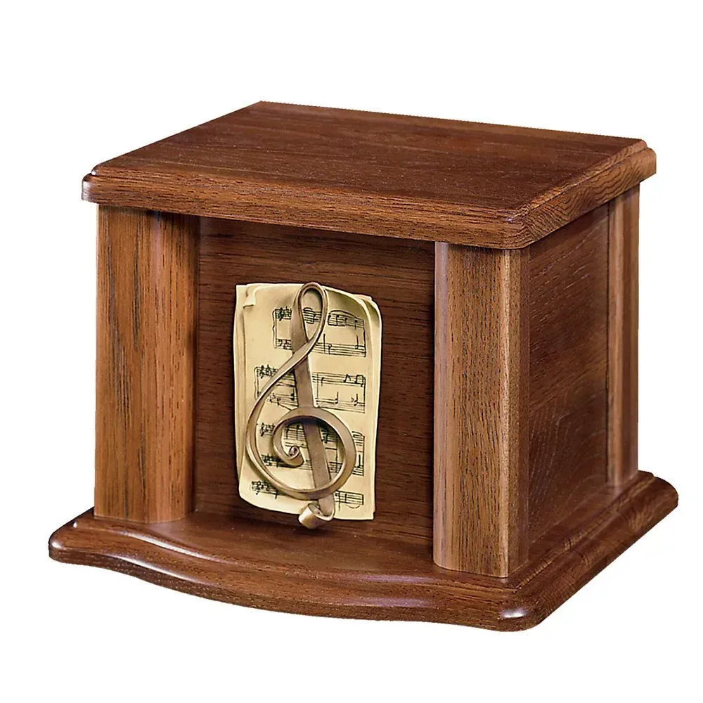 Wooden memorial box with a brass treble clef over sheet music on the front