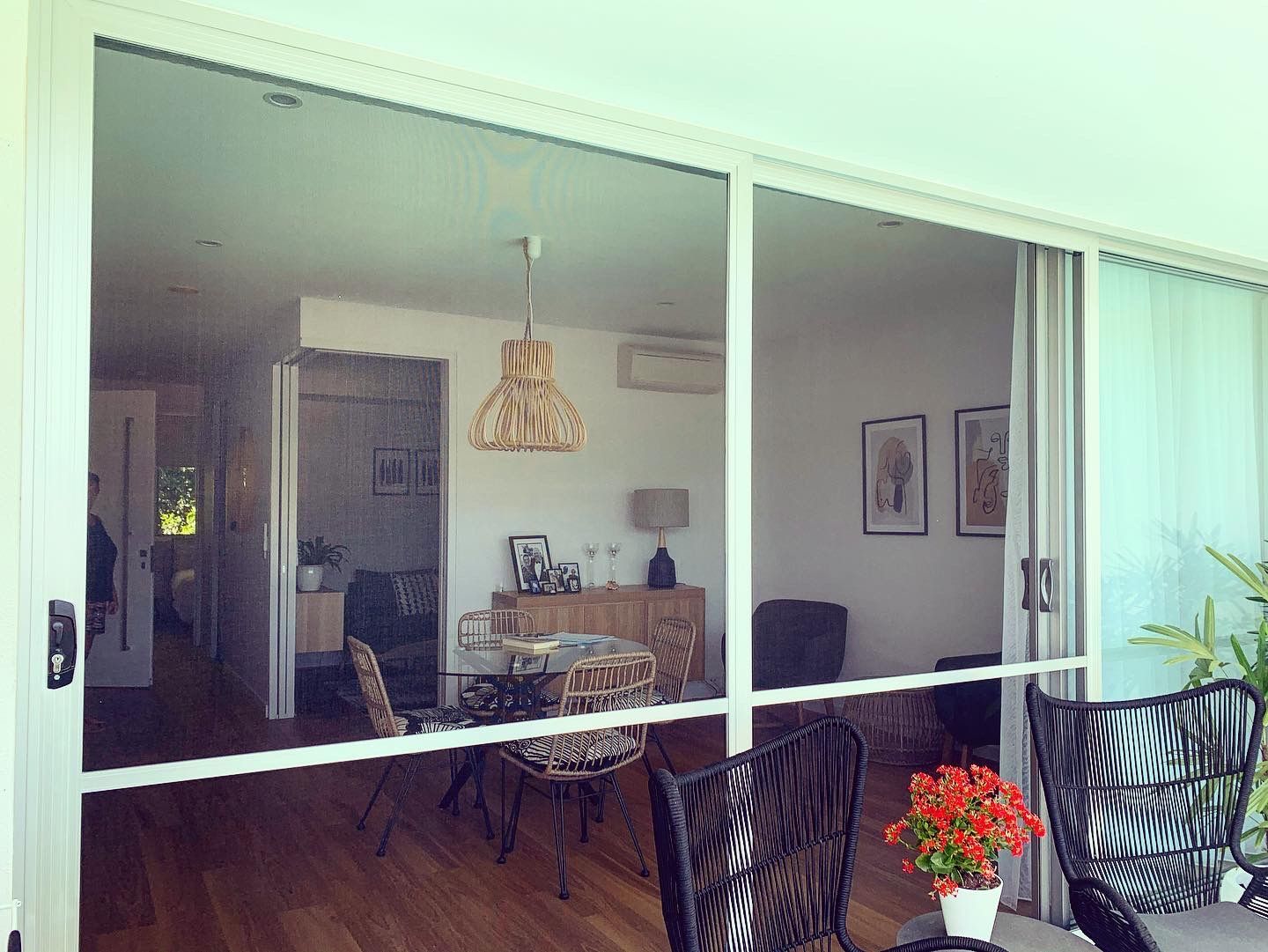 A living room with a dining table and chairs and a sliding glass door.