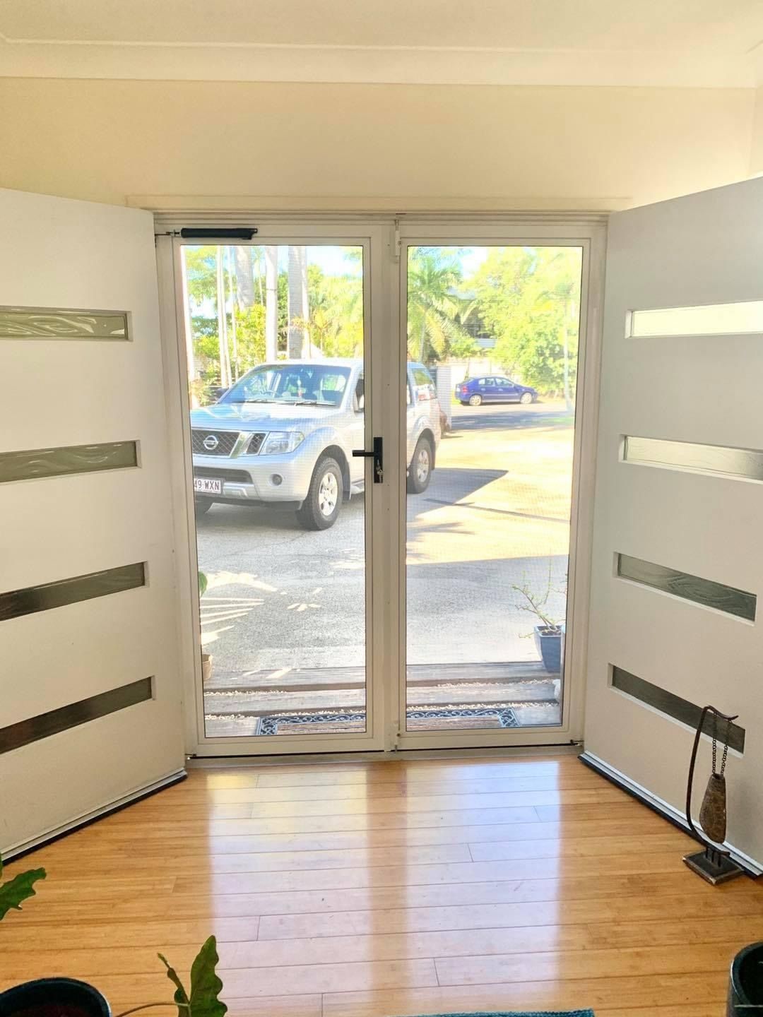 A car is parked in front of a door in a living room.