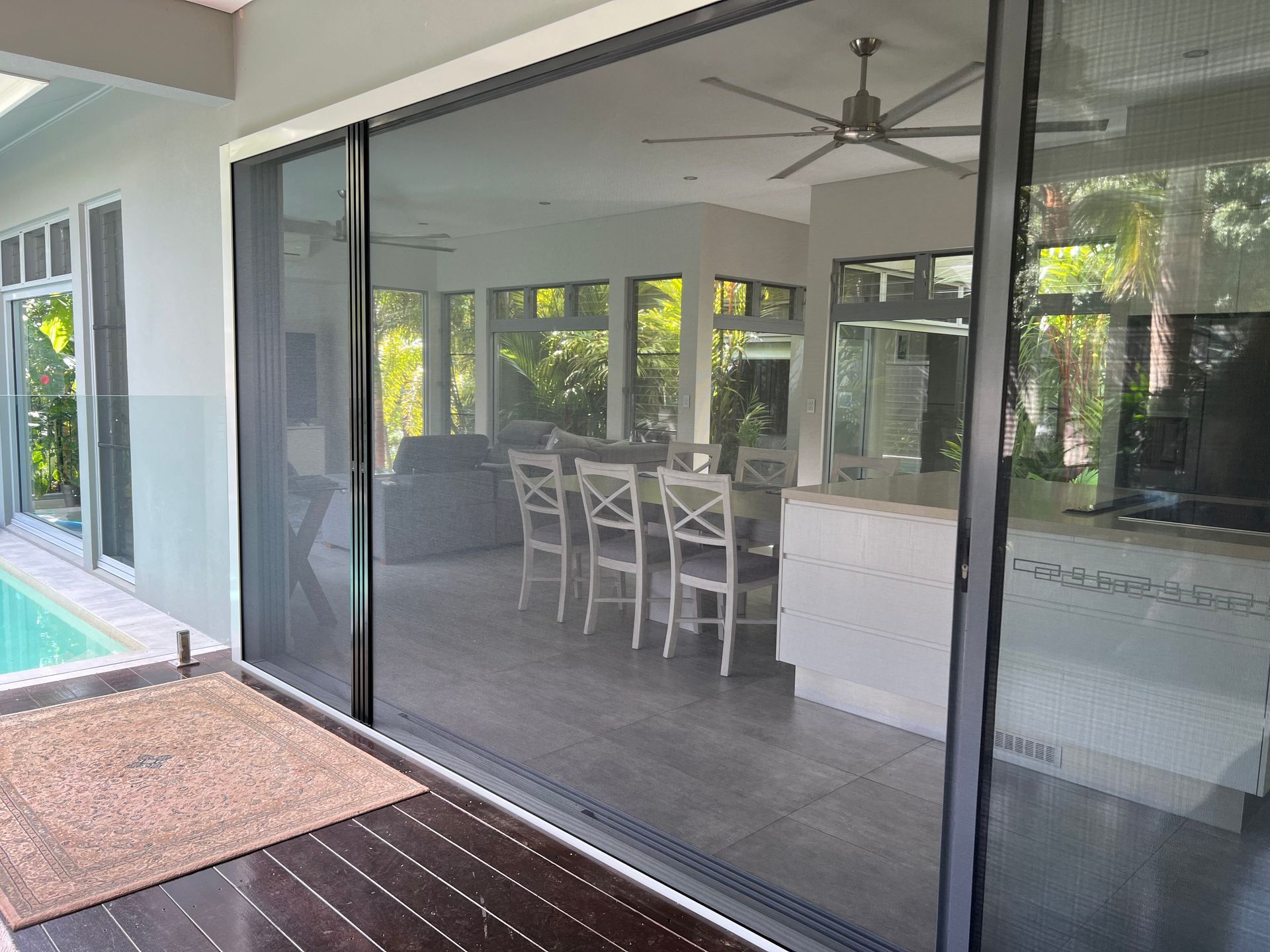A sliding glass door leading to a dining room and a swimming pool.