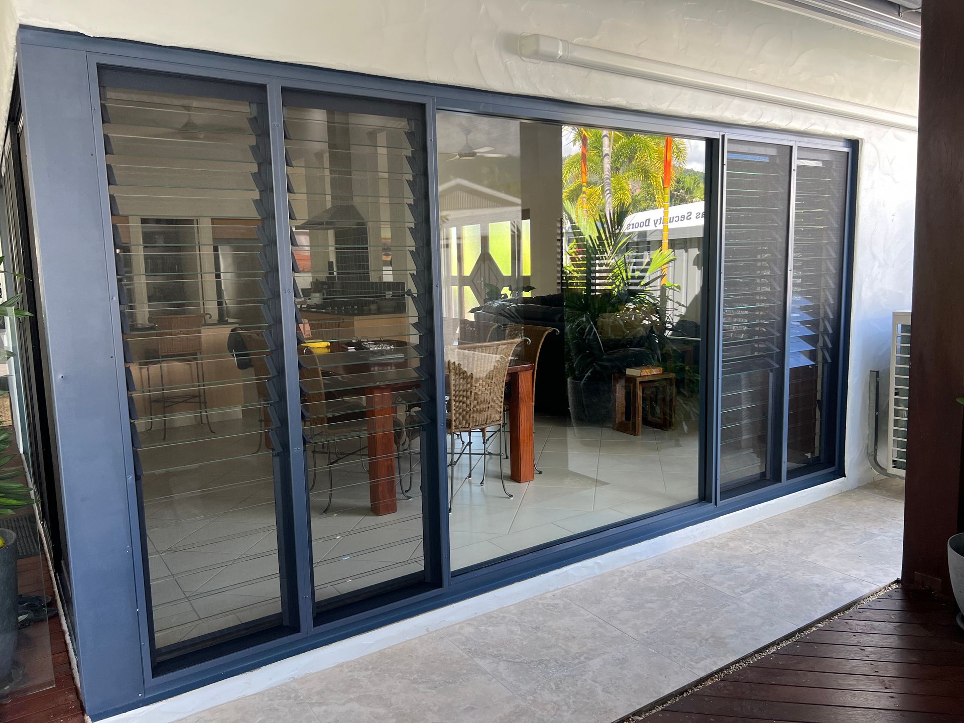 A large sliding glass door leading to a dining room in a house.
