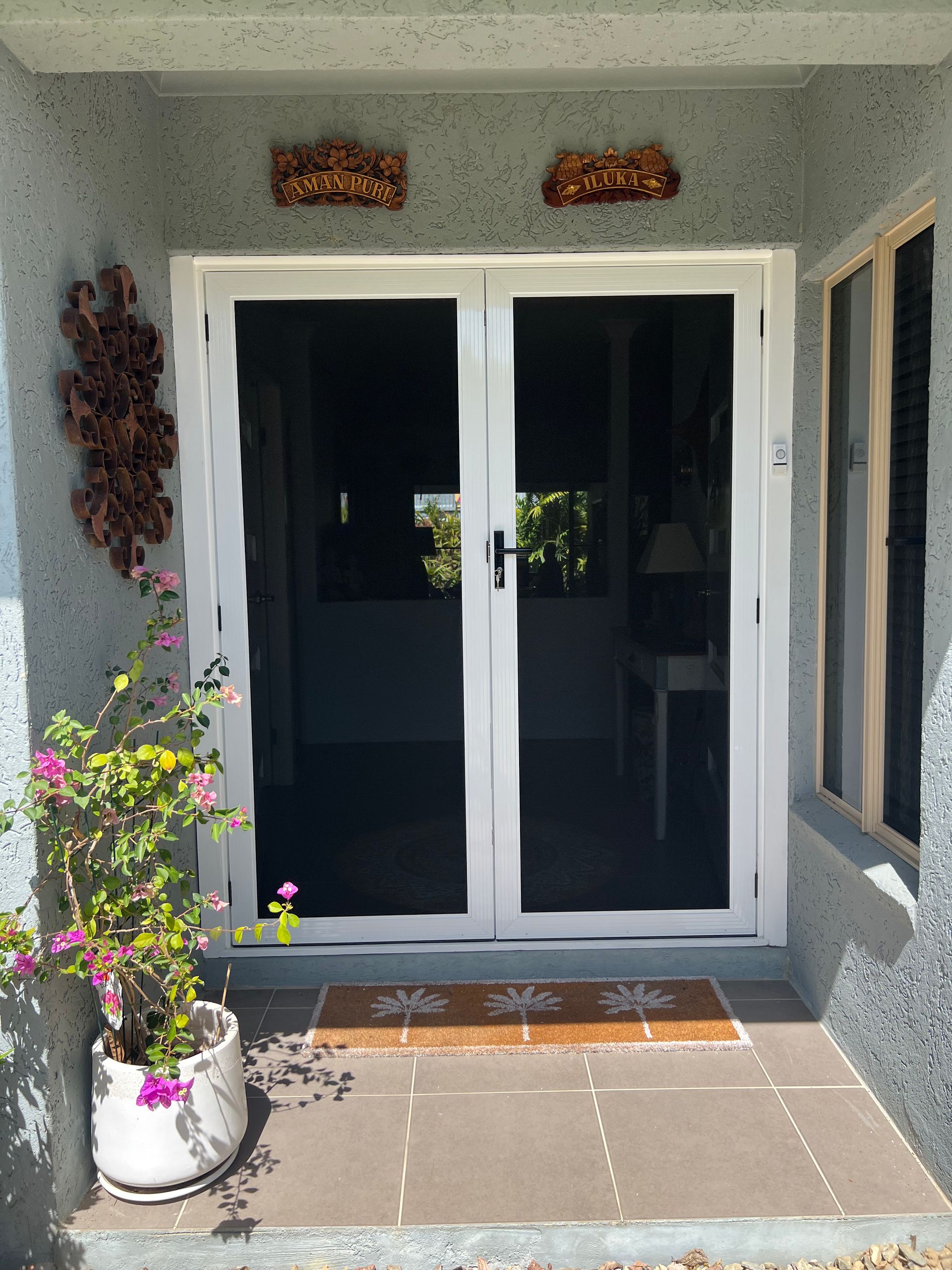 A house with a sliding glass door and flowers on the porch