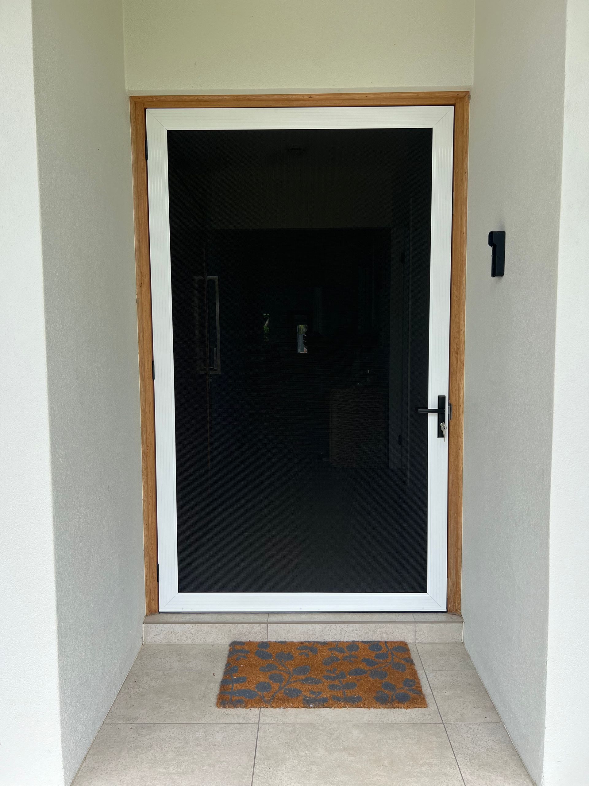 A white screen door with a number 1 on the wall