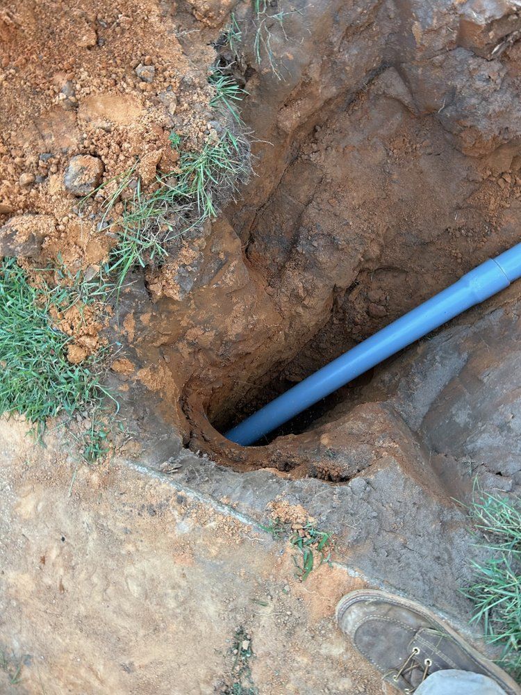 A large house with a garage and a driveway on a rainy day.