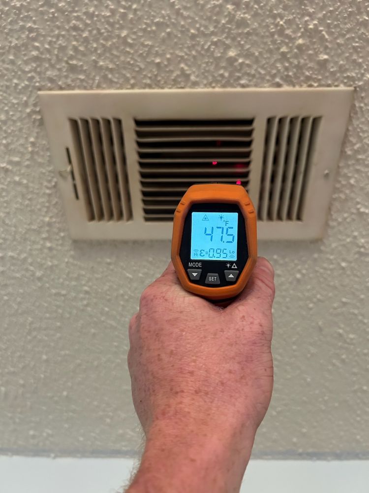 A large house with a garage and a driveway on a rainy day.