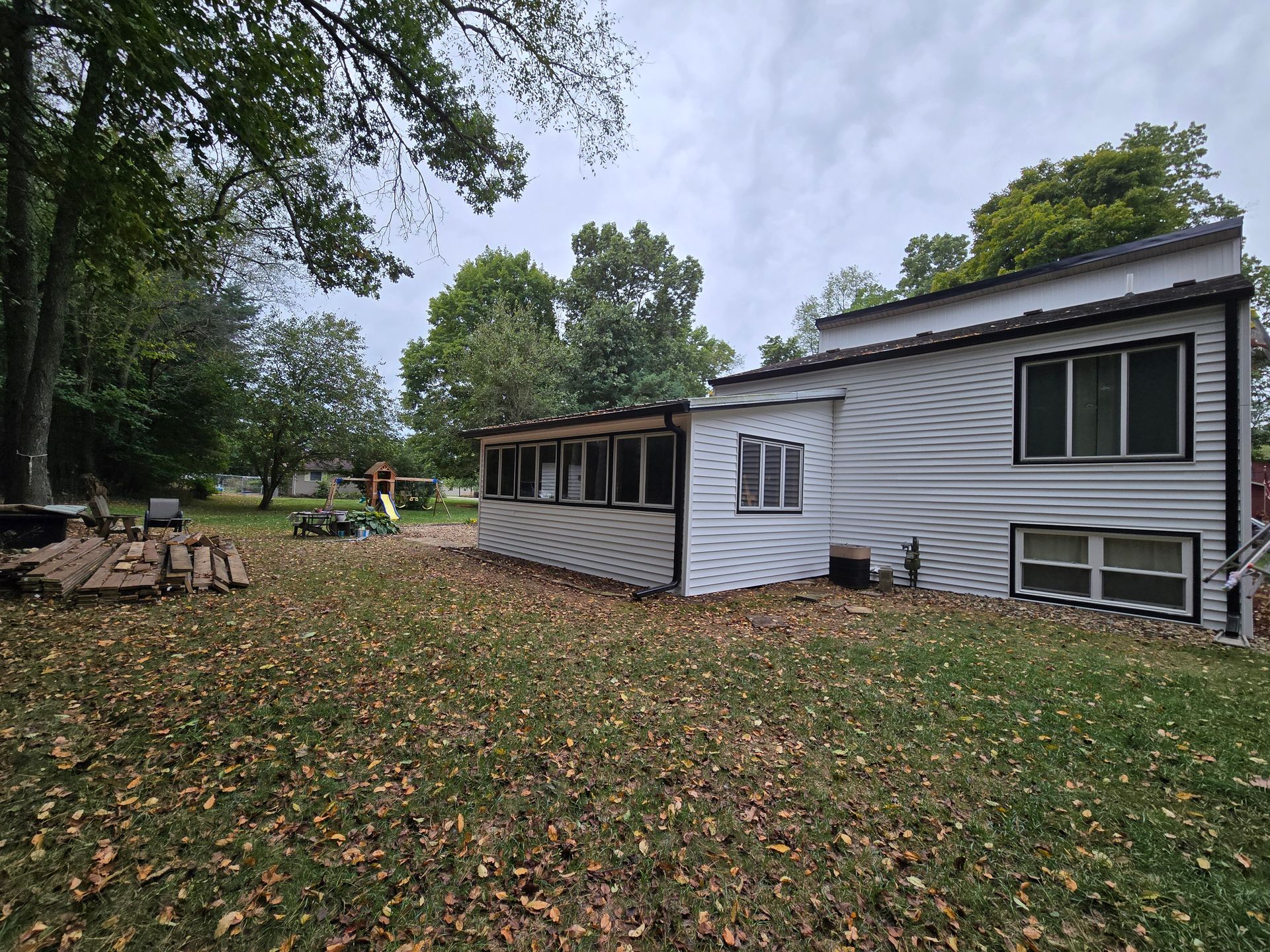 A white house is sitting on top of a lush green field.