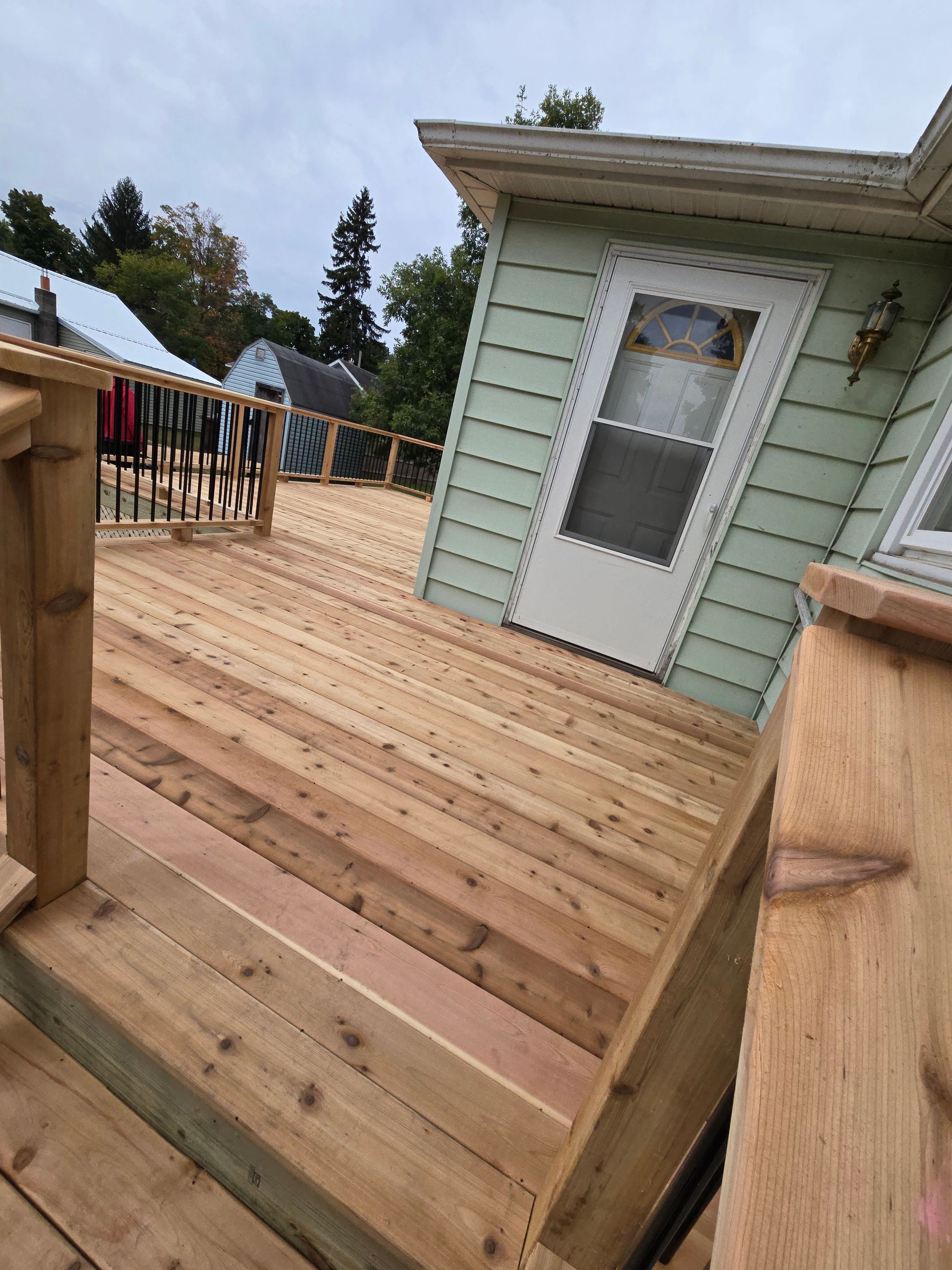 A wooden deck with stairs leading up to a house.