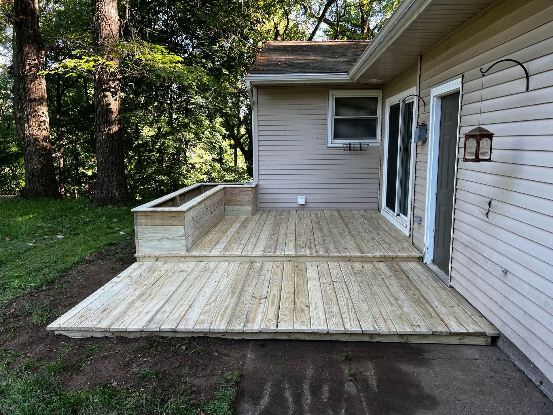 a wooden deck is sitting in front of a house .