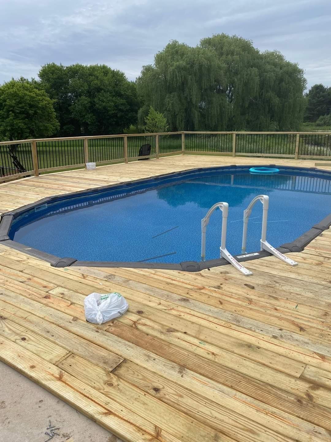 a large swimming pool surrounded by a wooden deck .