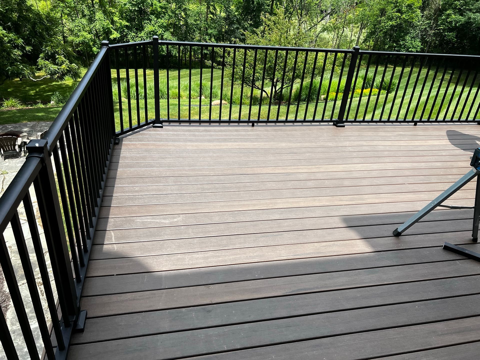 a wooden deck with a black railing and a table on it