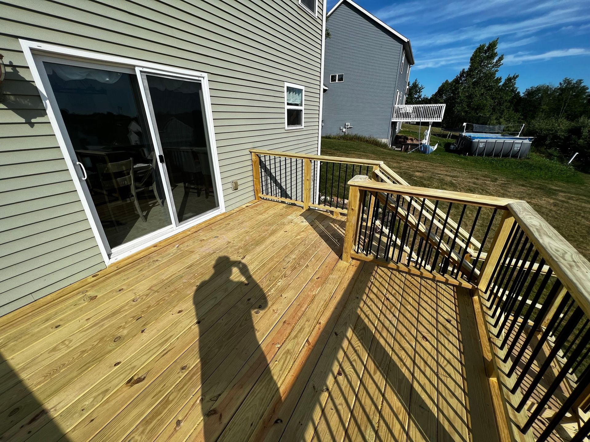 a wooden deck in front of a house with a sliding glass door .