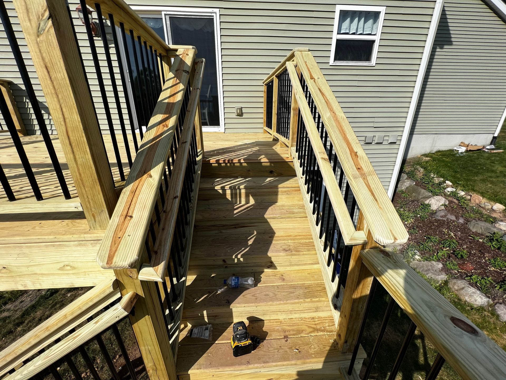 a wooden deck with stairs leading up to a house .
