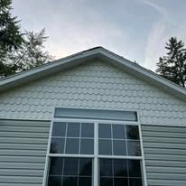 A white house with a large window and a roof.