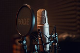 A close up of a rode microphone in a recording studio