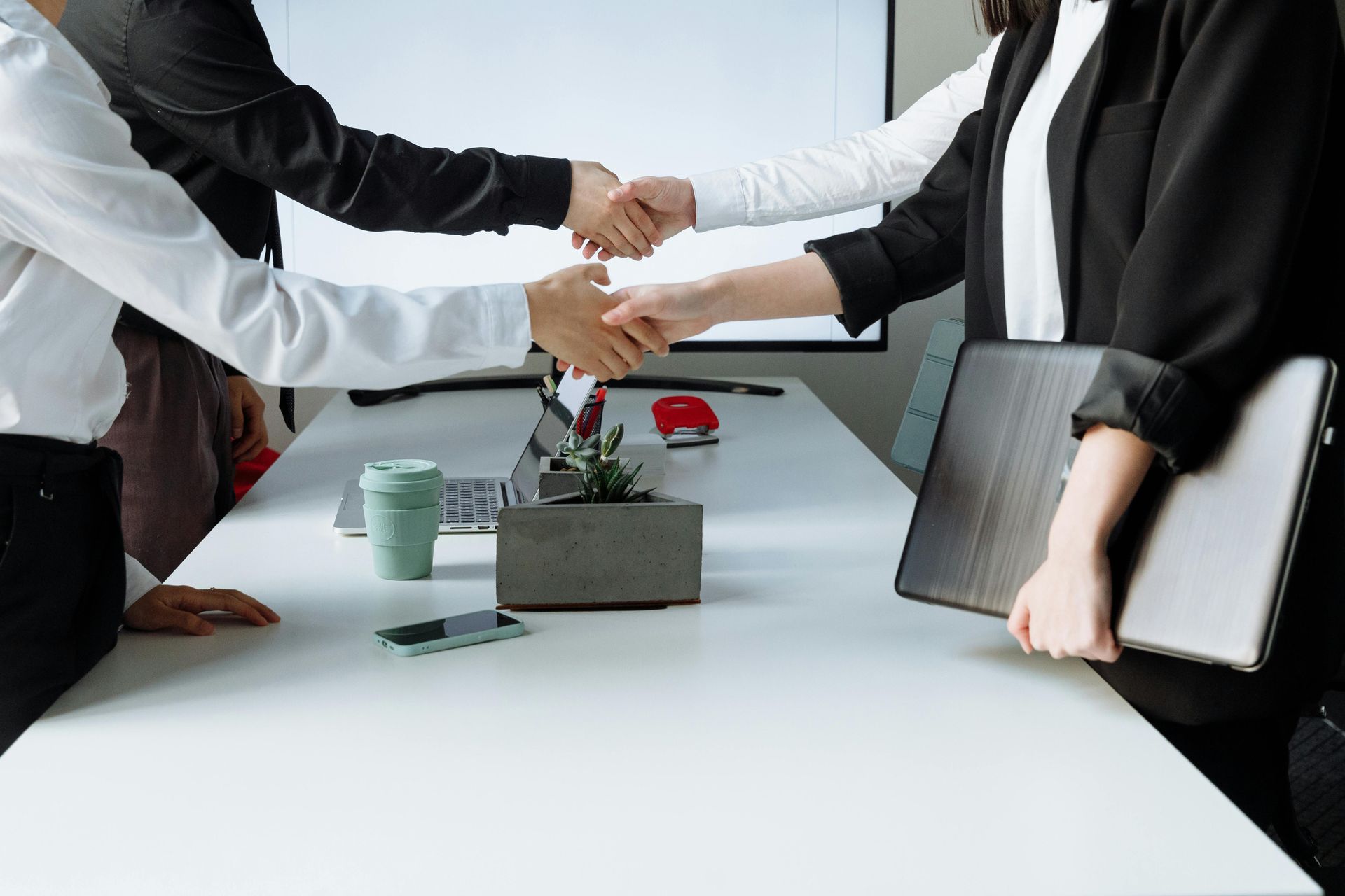A woman is shaking hands with a man in an office.