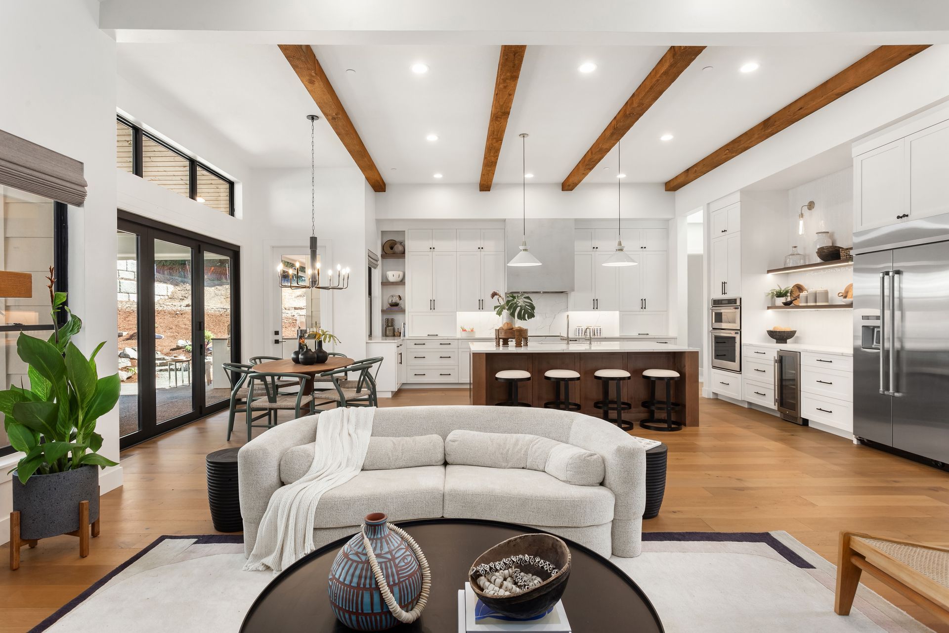 A living room with a couch , table , chairs and a kitchen.