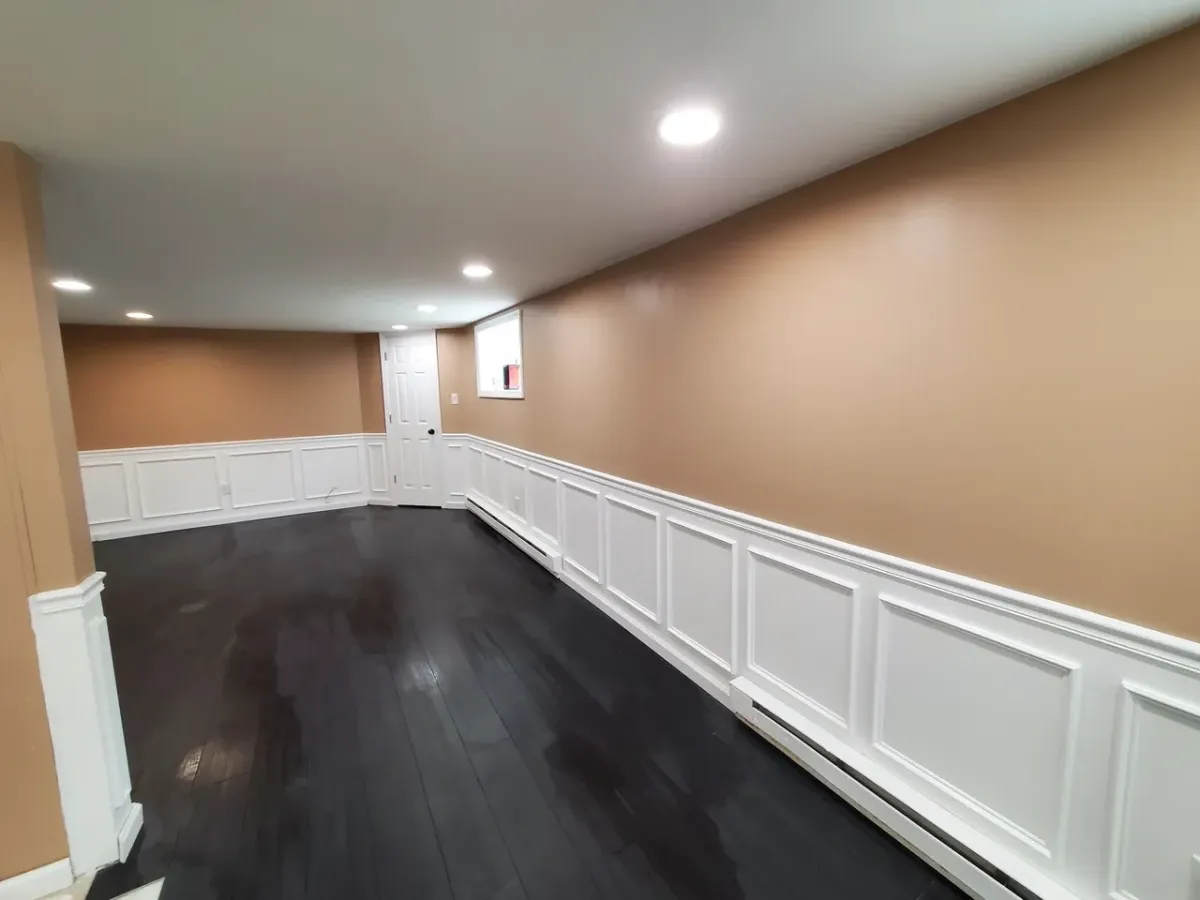 A room with brown walls and white trim and a black floor.